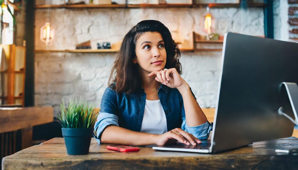 Local small business woman on long island, staring at her computer, thinking about if she should focus on local seo, or global seo.