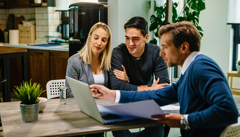 LinkedIn Sales Navigator 5 financial advisor helping young couple with their investments.