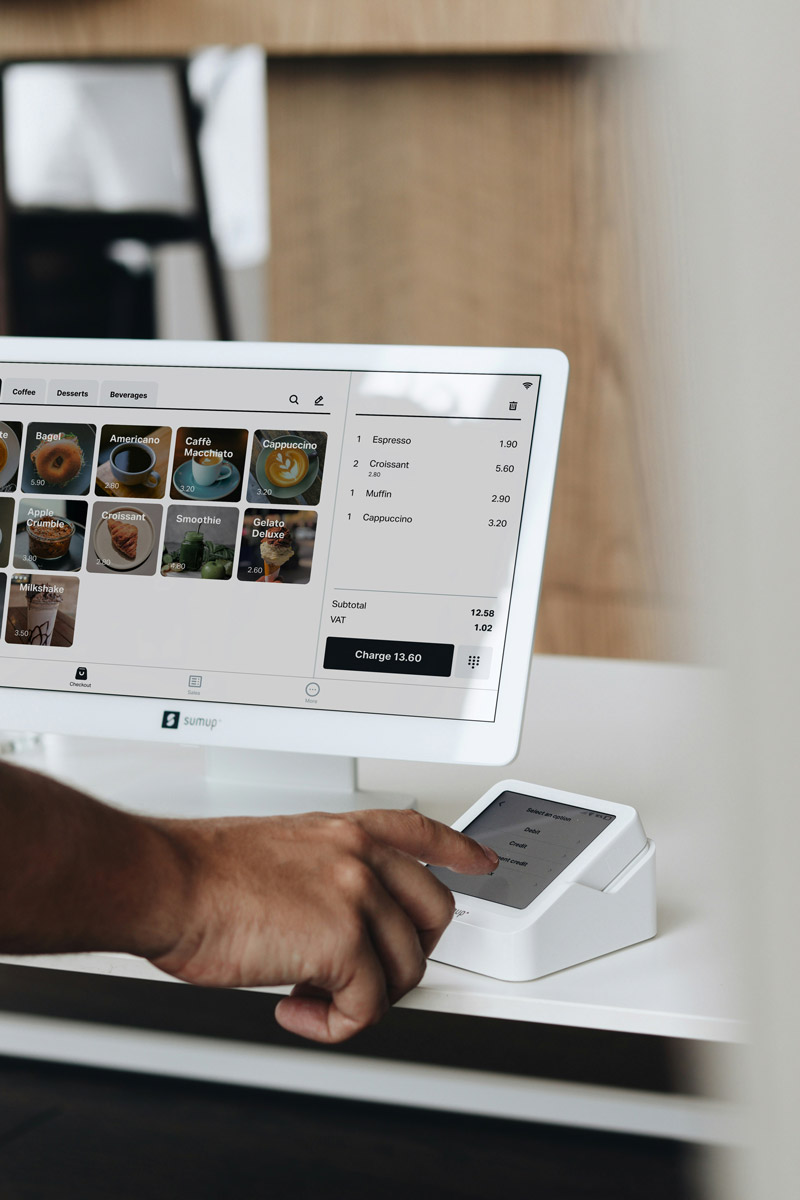 Cashier in Babylon store using their POS system and credit card reader.
